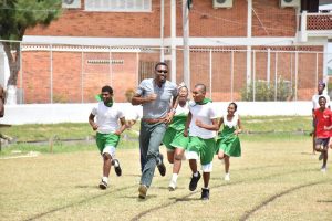 Director of Sport, Christopher Jones takes the lead as he sprints ahead of students from the Ministry of Education’s Unit for the Blind at the opening race of the second Special Schools Athletics Sports.