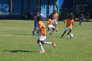 Part of the action between Enterprise and St. Ambrose in the Courts Pee Wee Primary Schools Football Championship at the Thirst Park ground yesterday.