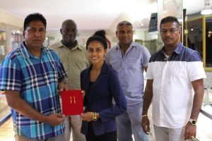 A representative of Steve’s Jewellery presents the pendants to Surendra Nauth in the presence of other GFSCA officials and Steve Naraine (right).