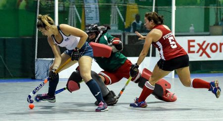 Alysa Xavier (center), goalkeeper of the Guyana team, in the process of making a timely save to deny Uruguay a goalscoring opportunity, in her team’s hard-fought loss at the Cliff Anderson Sports Hall in the Pan American Indoor Hockey Championship. 
