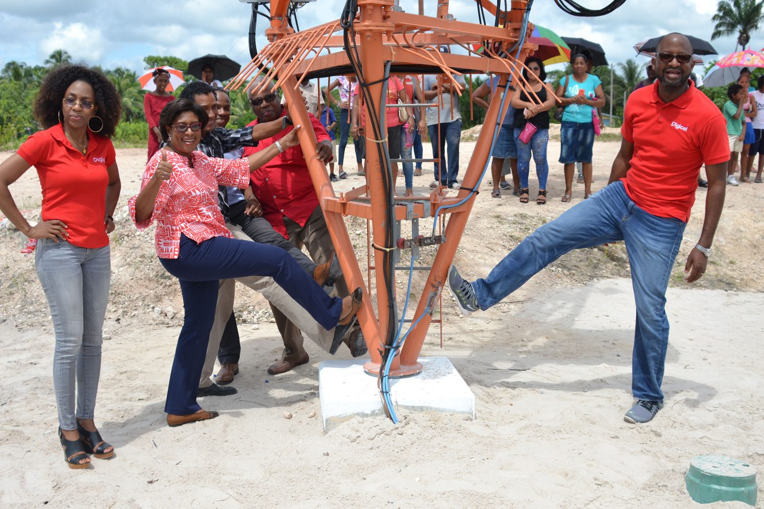 Minister of Public Telecommunications Catherine Hughes (left) and CEO of Digicel Gregory Dean kicking the cell tower, as is done when a new tower is erected. (DPI photo)
