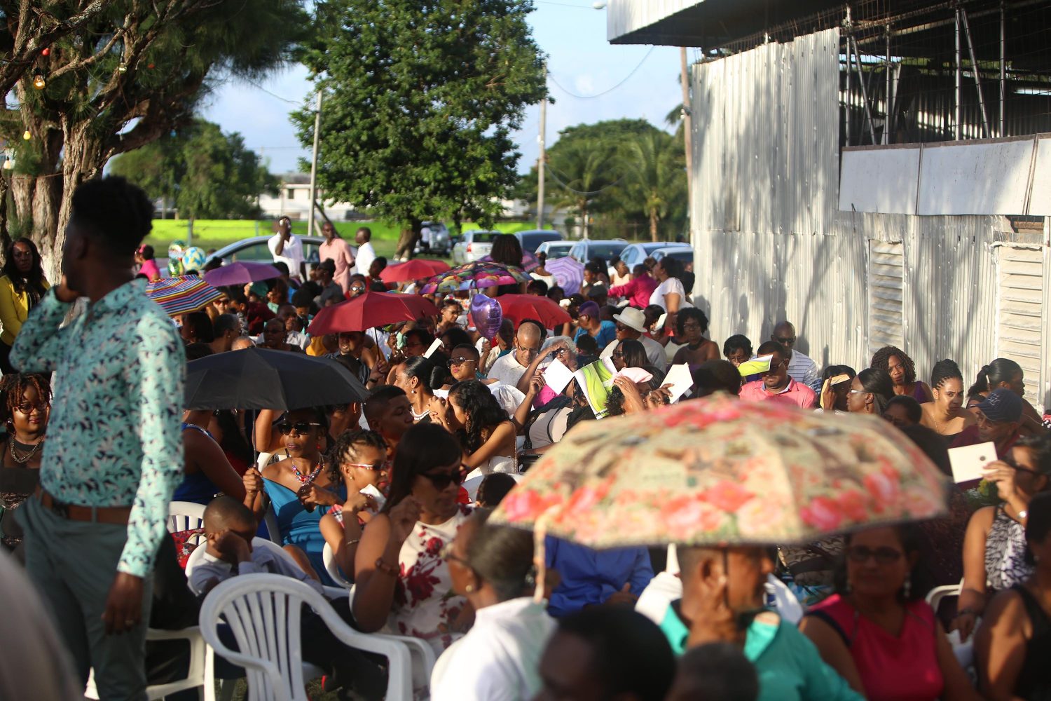 Family members sitting outside of the auditorium at the Sophia Exhibition Centre during the University of Guyana’s 51st Convocation yesterday afternoon. Photo by Keno George)