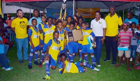 The victorious West Ruimveldt unit posing with their spoils after crushing Marian Academy 4-0 to secure the Pee Wee Primary School Football Championship at the Thirst Park ground. It was the second final’s appearance for both teams, with West Ruimveldt losing the 2013 finale and Marian Academy winning the 2012 accolade.(Orlando Charles photo)