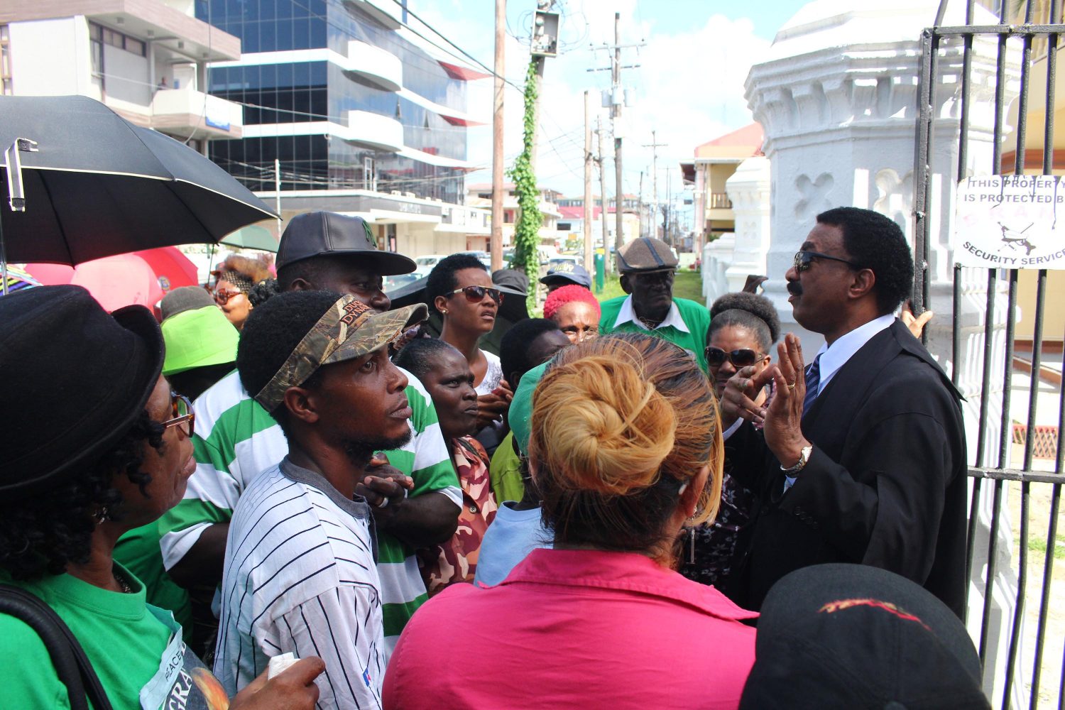 Attorney General Basil Williams (right) addressing supporters after calming them outside of the High Court.
