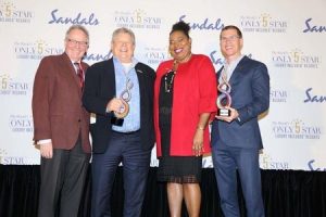 David McClung, president of Baxter Travel Media (left), presents the awards for 2017 Agents’ Choice Awards for favourite Responsible Travel Company and favourite All-Inclusive Hotel Brand, to Sandals chairman Gordon ‘Butch’ Stewart (second left) and deputy chairman and CEO Adam Stewart (right).  Also sharing in the moment is Maureen Barnes-Smith, director of sales 