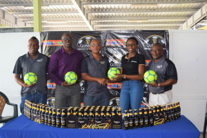 Three Peat Promotions, Rawle Welch (2nd from left), receives the symbolic ball from Colours Boutique representative Creanna Damon in the presence of Referees Coordinator Wayne Griffith (left), Guinness Brand Manager Lee Baptiste (2nd from left) and Banks DIH Limited Communications Director and tournament consultant Troy Peters