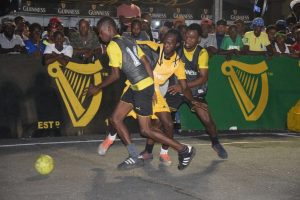 Daniel Favourite (centre) of Broad Street tussling with two Queen Street Tiger Bay players, during their group clash in the Guinness СGreatest of the Streets Georgetown Zone at the National Cultural Centre tarmac.