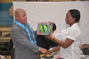 Minister of Social Cohesion with the responsibility for Culture, Youth and Sport, Dr. George Norton, handing over much needed sports gear to the Headteacher of Rose Hall Primary School,  Hollis Schweirs.  (Ministry of the Presidency photo)