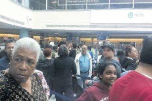 Frustrated passengers wait in line to go through Immigration at the Piarco International Airport on Sunday.