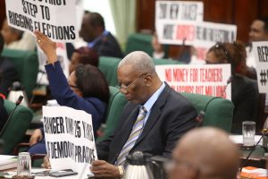 Placards being held up by PPP/C MPs on Thursday