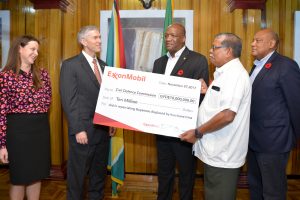 Rod Henson (second from left), ExxonMobil Guyana's Country Manager after handing over the cheque to Minister of State, Joseph Harmon (centre) and Director General of the Civil Defence Commission, Colonel Chabilall Ramsarup (second from right) as Minister of Natural Resources,  Raphael Trotman (right).  (Ministry of the Presidency photo)