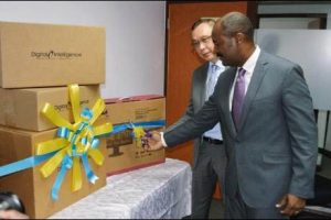 Contractor General Dirk Harrison (right) prepares to cut the ribbon to unveil equipment donated to the oversight body by the United States Government. Assisting Harrison is US Chargé d’affaires Eric Khant. 
