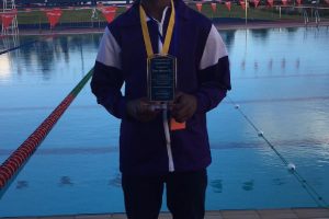 North Georgetown’s  (District 11) Leon Seaton is rewarded for breaking the 22-year-old boys under 14 50m backstroke record at yesterday’s GTU National Swimming Championships at the National Aquatic Centre, Liliendaal.