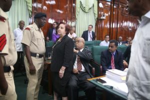 Opposition Chief Whip Gail Teixeira stands between Opposition Parliamentarian Juan Edghill and the police. Speaker Barton Scotland had ordered that Edghill be removed from the House after he repeatedly refused to respond to a directive to sit. He was ruled “out of order”. 