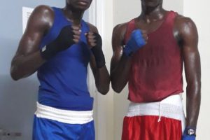 Colin Lewis (left) and Barbados’ Justin Edwards pose for a photo prior to their light welterweight bout on Wednesday night. Lewis went on to stop Edwards in the second round.