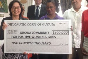 Head of the GCWAG Marlyn Cameron receives a monetary donation from the diplomatic community in Guyana which the organisation will use to help its members deal with depression. 