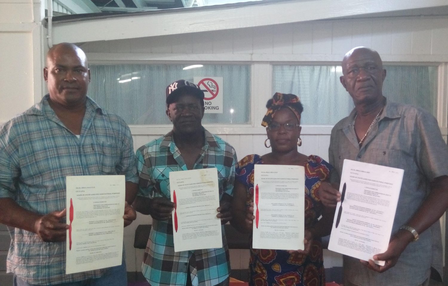 Revoked leases: Rice farmers (from left) Rawle Miller, Rupert Blackman, Doreen Monah and Philip Alexander Johnson holding up their leases.