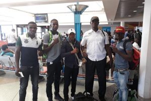 Coach Terrence Poole and the four boxers pose for a photo at the Grantley Adams International Airport en route to St Lucia yesterday. 