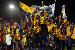 Athletes and officials of Upper Demerara/Kwakwani celebrating last evening at the National Track and Field Centre with their Champions of Champions trophy with Non-Alcoholic Brand Manager from Banks DIH Limited, Clayton McKenzie. (Orlando Charles photo) 