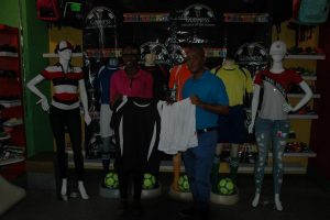 Colours Boutique representative Creanna Damon (left) hands over the uniforms to Three Peat Promotions Rawle Welch, coordinator of the event’s Georgetown, East Coast Demerara and National Championship, at their Robb Street location. In the background are several mannequins featuring some of the uniforms that will be worn by the competing teams in the knockout stages of the Guinness ‘Greatest of the Streets’ Georgetown Championship