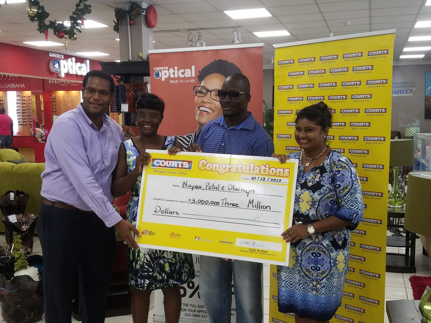 Courts million-dollar winners: From right are Petal Surujpaul, Olwin Lynch, Nayaa Rose and a Courts representative