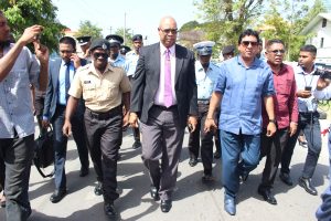 PPP/C MP Juan Edghill (centre) and some of his party colleagues walking to the Brickdam Police Station today.