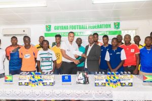 Top Brandz Distributor Marketing Manager, Marvin Wray (left), hands over the sponsorship cheque to GFF President Wayne Forde at the official launch of the Corona Beer ‘Super 16 year-end Classic’ in the presence of the participating teams. (Orlando Charles photo)
