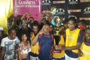 Captain Jamal Pedro (right) of Gold is Money, posing with the championship trophy, alongside several team-mates and fans, following their 1-0 over Sparta Boss in the Guinness ‘Greatest of the Streets’ Georgetown Championship 