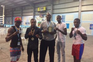 Coach Terrence Poole (centre) is flanked by his medal winning charges of the Caribbean Development Boxing Tournament which concluded on Saturday night in St Lucia. From left are silver medallist, Joel Williamson and gold medallists, Keevin Allicock, Colin Lewis and Desmond Amsterdam. 