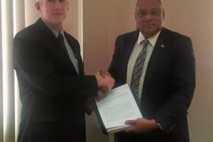 ExxonMobil Country Manager Rod Henson (left) and Minister of Natural Resources Raphael Trotman with the production licence on June 15 this year. (Ministry of Natural Resources photo)