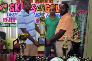 Tournament Coordinator Borris Ross, (left) collects the trophies from Ansa McAl’s Trade Marketing Assistant for the West Coast Berbice area, Lynton Luke. Also present is STAG Beer Brand Representative Lyndon Henry (centre).
