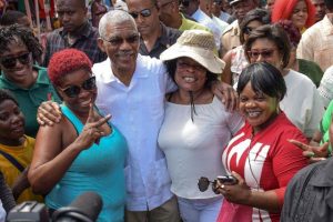 President David Granger yesterday joined vendors, businesses proprietors and last minute shoppers in the Stabroek Market and its environs for a walkabout and meet and greet exercise to enjoy the traditional hustle and bustle of Christmas Eve in Guyana.  The Head of State walked from Parliament Buildings to the market, greetings shoppers and vendors inside and outside of the commercial centre, a release from the Ministry of the Presidency said. Here he is pictured with some enthusiastic members of the public.