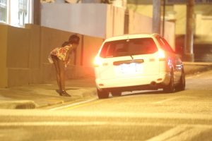 A sex worker speaks to a driver in Woodbrook.