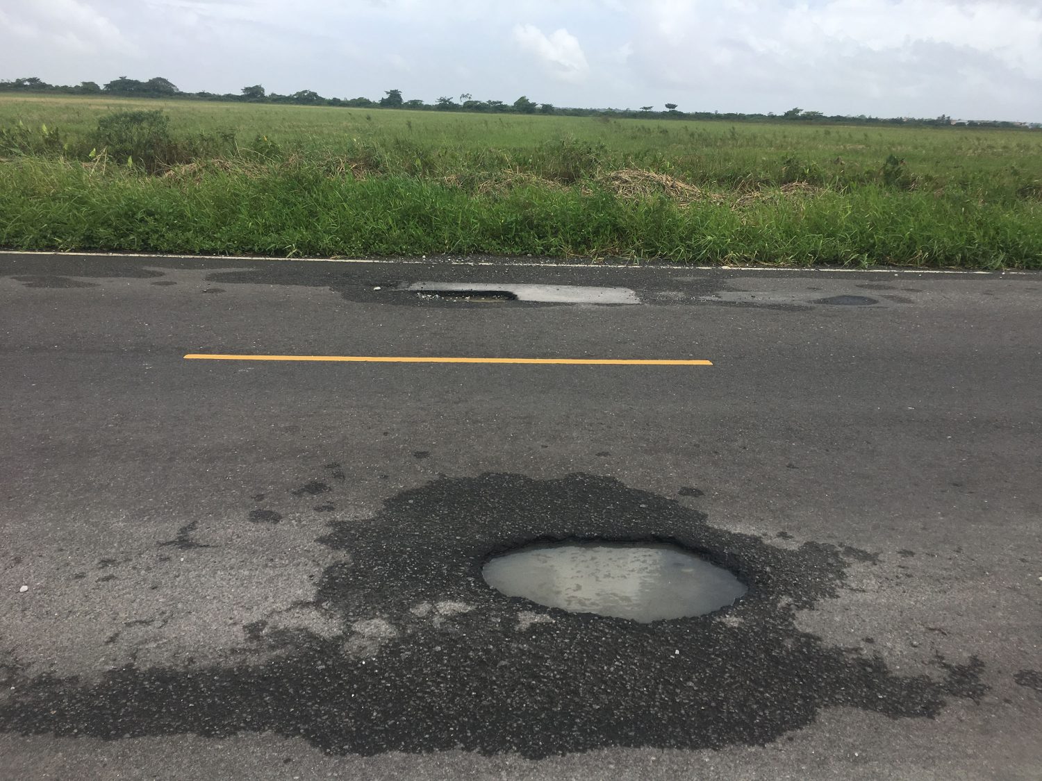 Two large potholes in both lanes of the Parfaite Harmonie Access Road 