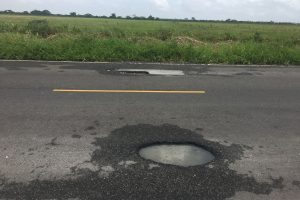 Two large potholes in both lanes of the Parfaite Harmonie Access Road 
