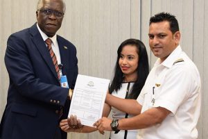 Director General of the Guyana Civil Aviation Authority (GCAA) Lieutenant Colonel (Ret’d) Egbert Field (left), hands over the certification to Chief Executive Officer of Domestic, Orlando Charles and his wife Komal Devi Charles. (Department of Public Information photo) 