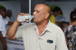 Sampling his brand: Roopan Ramotar drinking his Rooster coconut water
