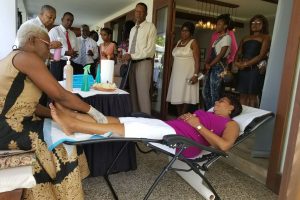 Minister of Public Telecommunications Cathy Hughes was the first to be treated to a foot massage by the CEO of Rovan Home Health Care herself.
