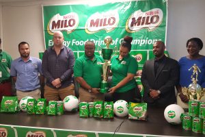 Co-Director of the Petra Organization Troy Mendonca (centre) collecting the championship trophy from Brand Manager Christel Van Sluytman following the official launch of the 6th Milo U18 Secondary Schools Football Tournament. Among the members of the launch party are Petra Representative Mark Alleyne (left), Ministry of Education Allied Arts Department representative Nicholas Fraser (2nd from left), GFF Technical Director Ian Greenwood (3rd from left) and Director and Executive Officer of M. Beepats and Sons Jonathan Beepat (2nd from right)