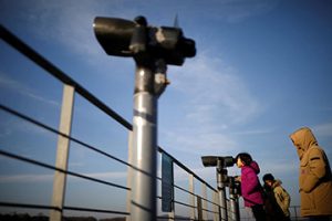 A girl looks toward the North through a pair of binoculars near the demilitarized zone separating the two Koreas in Paju, South Korea, January