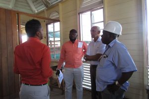 Project Engineer, Naeem Khan (backing camera) explaining the plan for the upper flat of the Kitty Market to the Minister of Communities Ronald Bulkan (second from right) while officials from City Hall listen in. (Ministry of Communities photo)