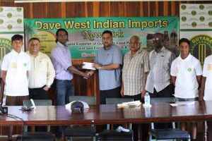 Representative of Dave West Indian Imports, Amar Ramraj hands over the cheque to GCB treasurer Anand Kalladeen.
