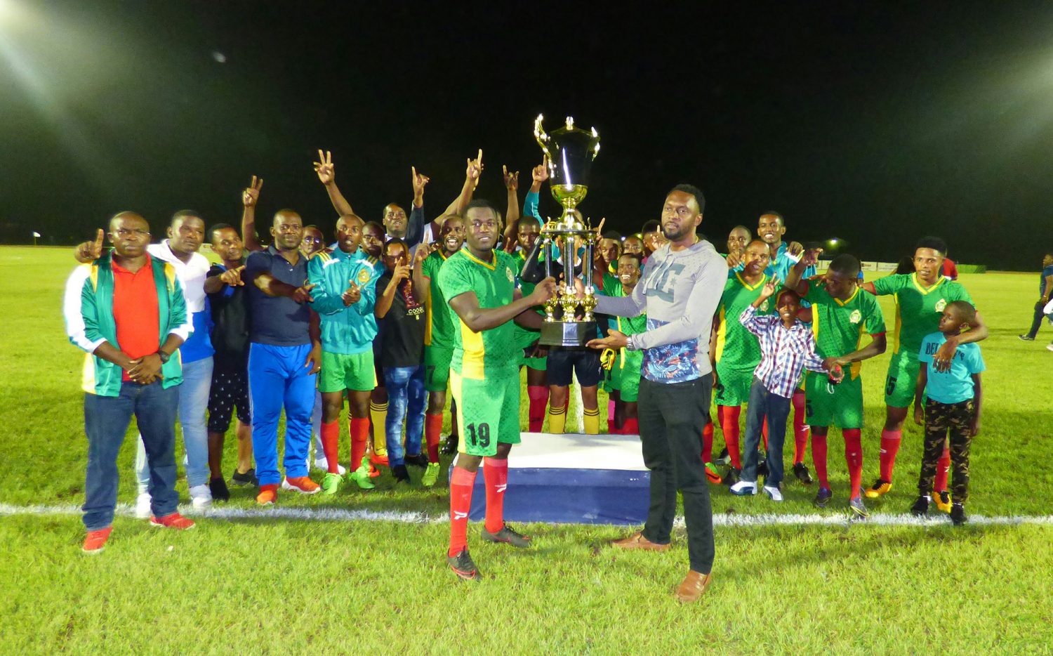 Director of Sports Christopher Jones, handing over the championship trophy to the GDF captain in the presence of teammates and supporters, following their 2-0 win over Grove Hi-Tech in the Guyana Football Federation (GFF) ‘Super 16 Year-end Classic’ champion, at the National Track and Field Centre, Leonora. 
