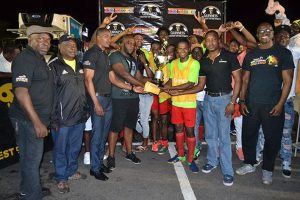 Flashback! Captain of Showstoppers Hubert Pedro seen collecting the championship trophy from Colours Boutique owner Robeson Brotherson after they defeated Hustlers 2-0 in the 2017 edition of the Guinness Greatest of the Streets West Demerara/East Bank Demerara zone