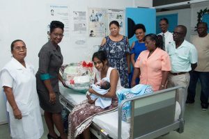 Hollis Kellman (second from left), Republic Bank representative hands over a hamper put together by the bank for the baby. (DPI photo)