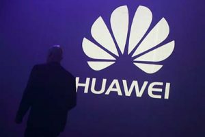 FILE PHOTO - A man walks past a logo during the presentation the Huawei's new smartphone, the Ascend P7, launched by China's Huawei Technologies in Paris, May 7, 2014.  REUTERS/Philippe Wojazer/File Photo