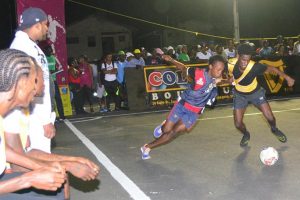 Flashback-Hustlers Sunil Logan (right) tussles with a Bagotstown Ballers player for possession of the ball at the Pouderoyen Tarmac in the third annual Guinness ‘Greatest of the Streets’ West Demerara/East Bank Demerara zone.