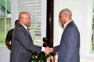 President David Granger (right) and Opposition Leader Bharrat Jagdeo greeting each other today. (Ministry of the Presidency photo) 
