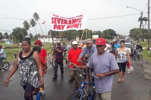Pay severance! Former Rose Hall sugar workers and their families marched yesterday for their severance pay after being laid off by GuySuCo last year. (See story on centre pages)