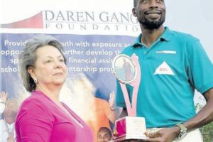 Sir Curtly Ambrose, right, collects a special award from Rosalind Gabriel, the owner of Prestige Awards Ltd. 